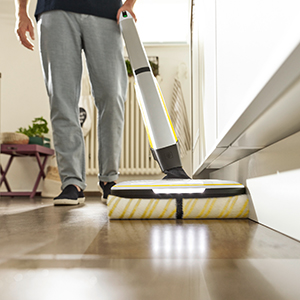 A person cleaning the edge of a skirting board A person cleaning the edge of a skirting board
